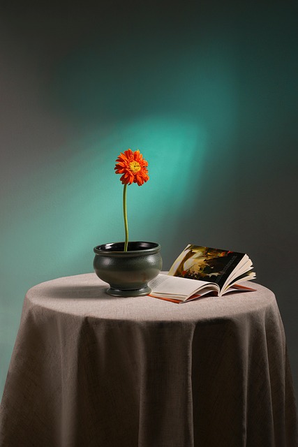 Person trimming flower stems and arranging fresh blooms in a vase on a sunlit kitchen table